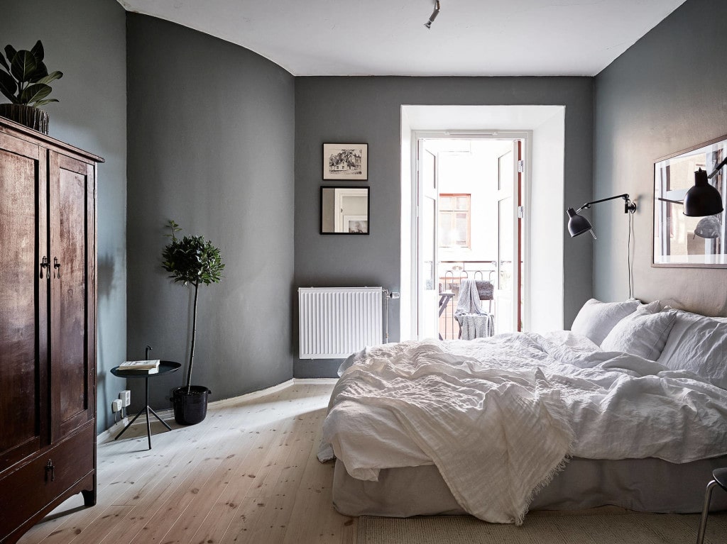 A dark grey bedroom with a warm wood antique wardrobe