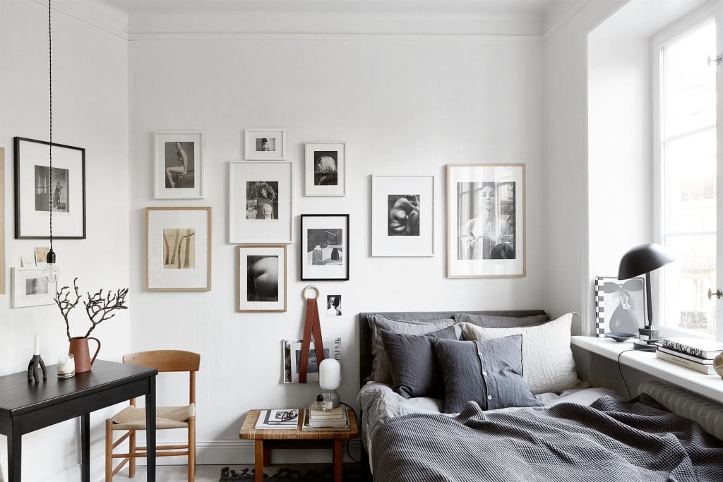 A studio apartment with a gallery wall above the bed