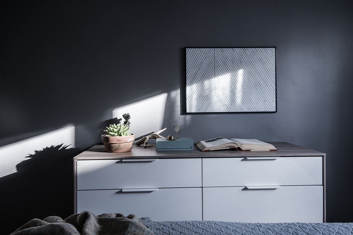 Cool dark grey bedroom brightened up with white and blue