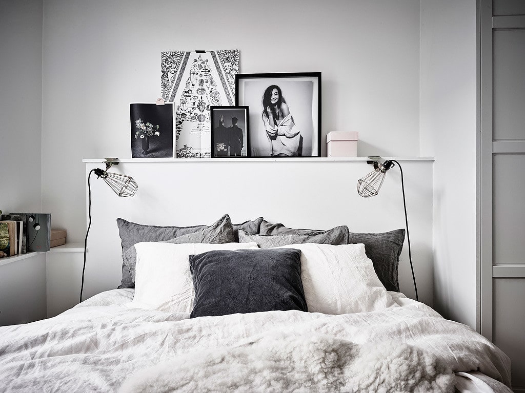 A ledge behind the bed with art frames leaning against the wall