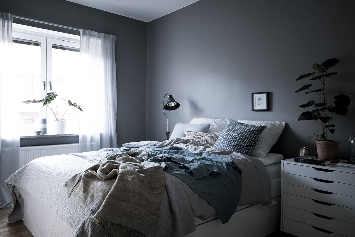 Cool dark grey bedroom brightened up with white and blue