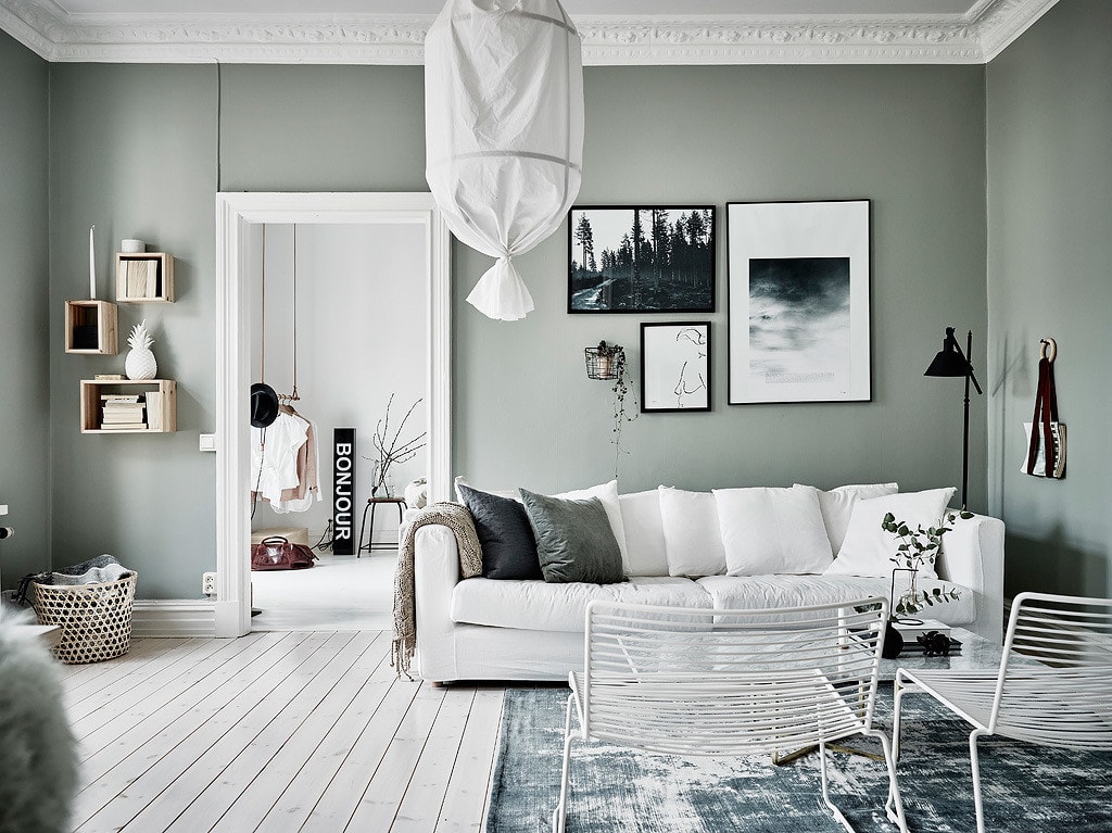 Sage green living room walls, white sofa, white floors