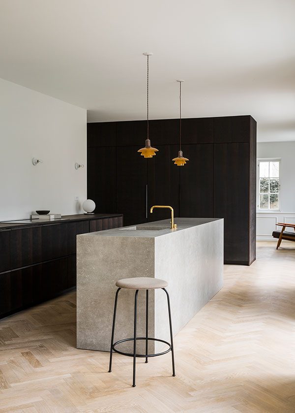 A minimal kitchen design with a grey marble island and smoked oak kitchen cabinets