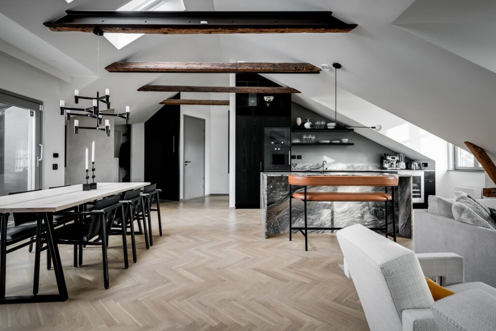A grey marble kitchen island in a black attic kitchen
