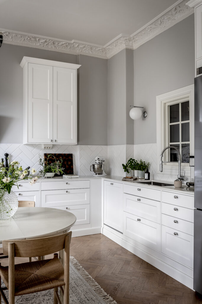 Crisp white shaker kitchen cabinets paired with a herringbone tile backsplash