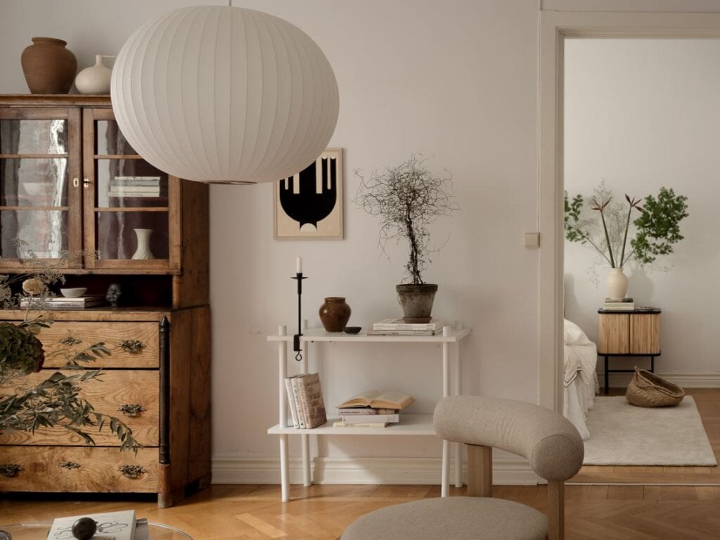 A living room with off-white walls, a natural decor and vintage furniture pieces