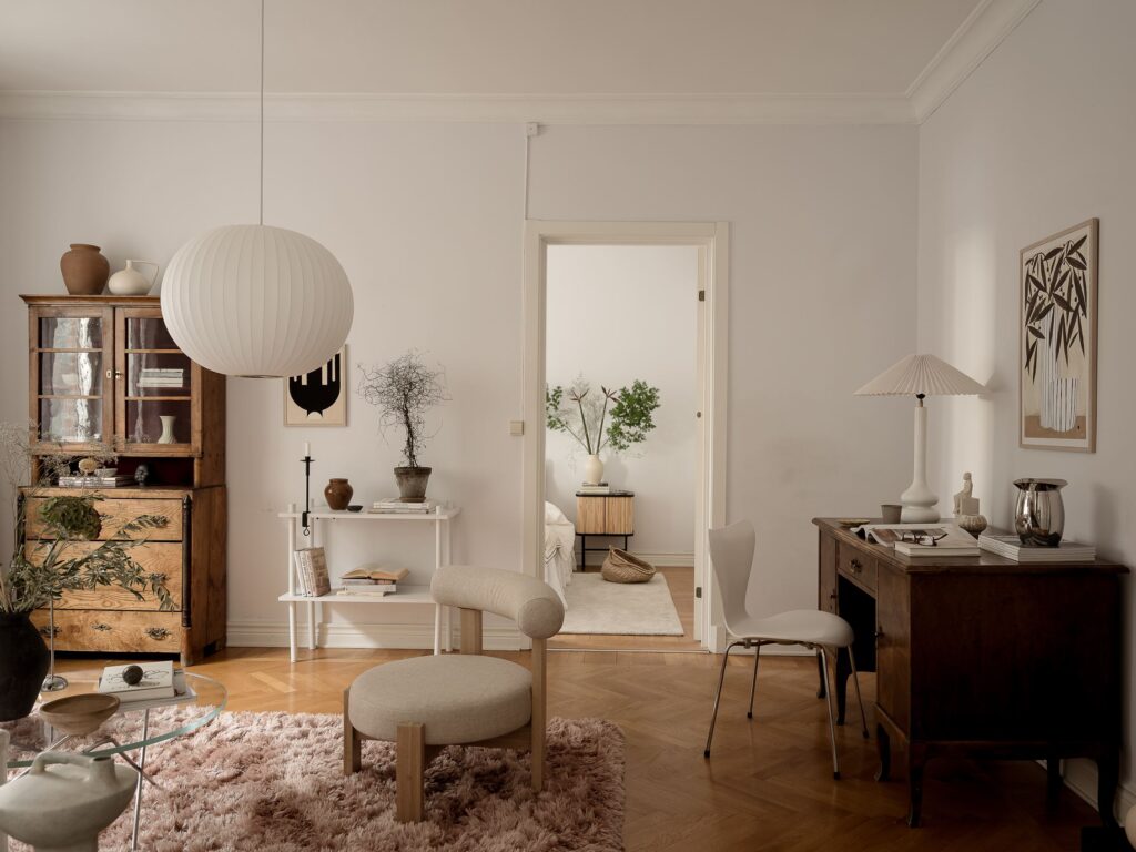 A living room with off-white walls, a natural decor and vintage furniture pieces
