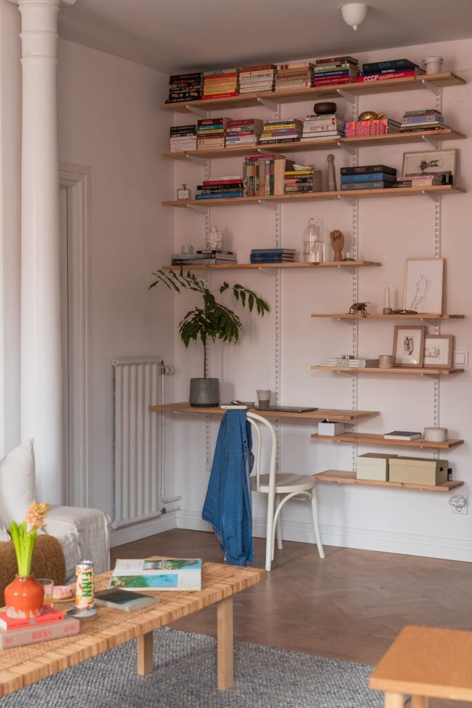 An open-plan living space with a wall shelf including a desk 