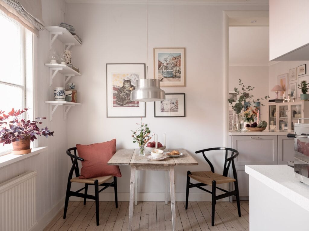 A kitchen dining area with black Wishbone chairs and a vintage dining table