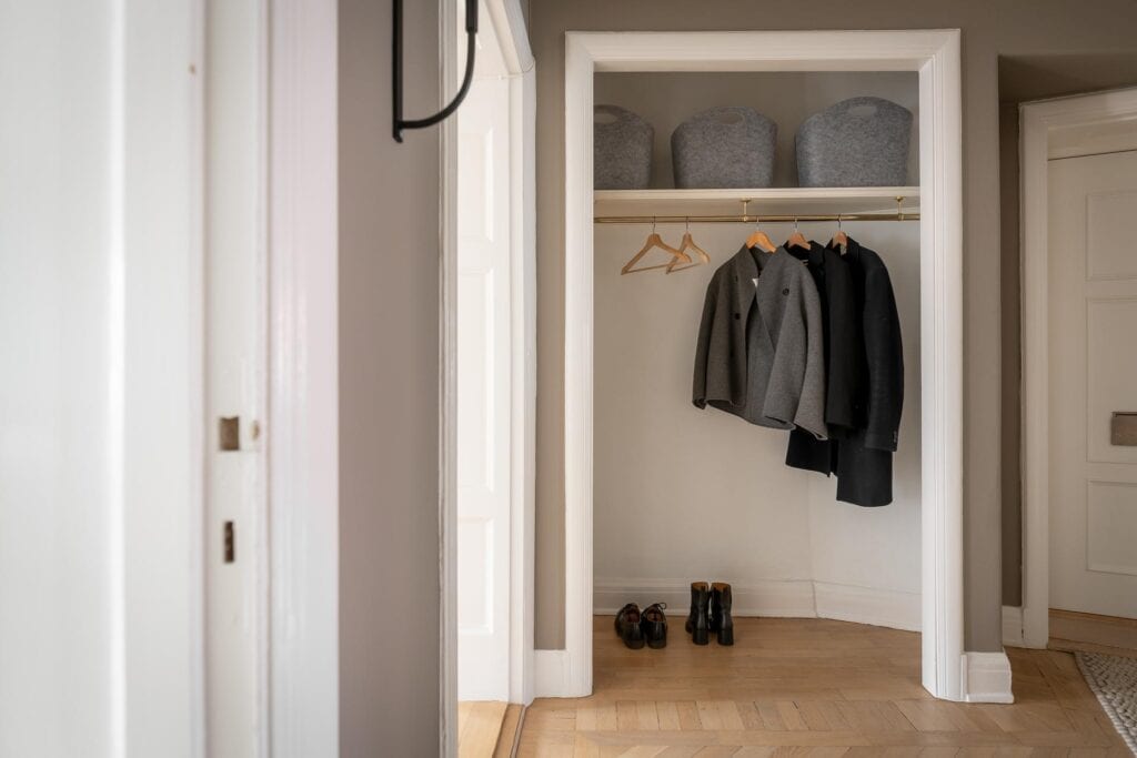 A dark grey hallway with a niche space for storing jackets and shoes