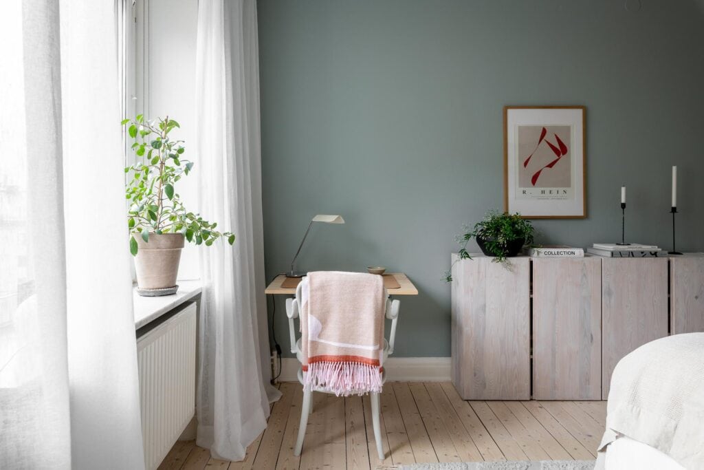 A sage green bedroom with a desk area and Ikea Ivar storage modules