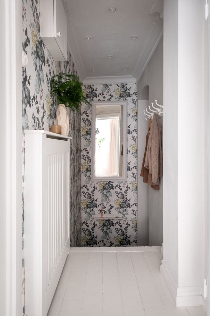 A small entryway with a floral wallpaper