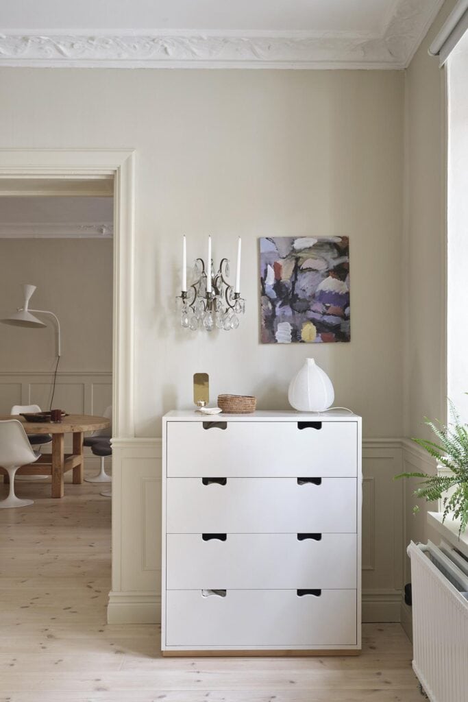 A white bedroom dresser against off-white bedroom walls