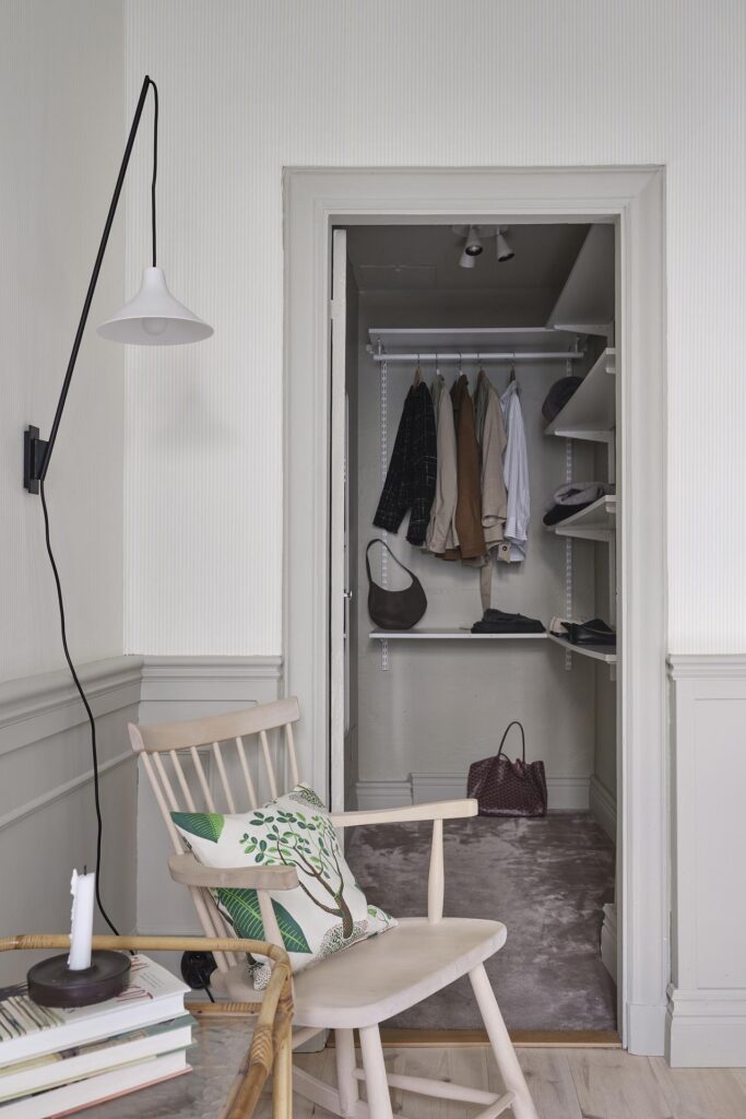 A carpeted walk-in closet with shelves attached to the wall