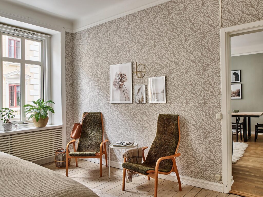 A beige pattern bedroom wallpaper paired up with olive vintage lounge chairs
