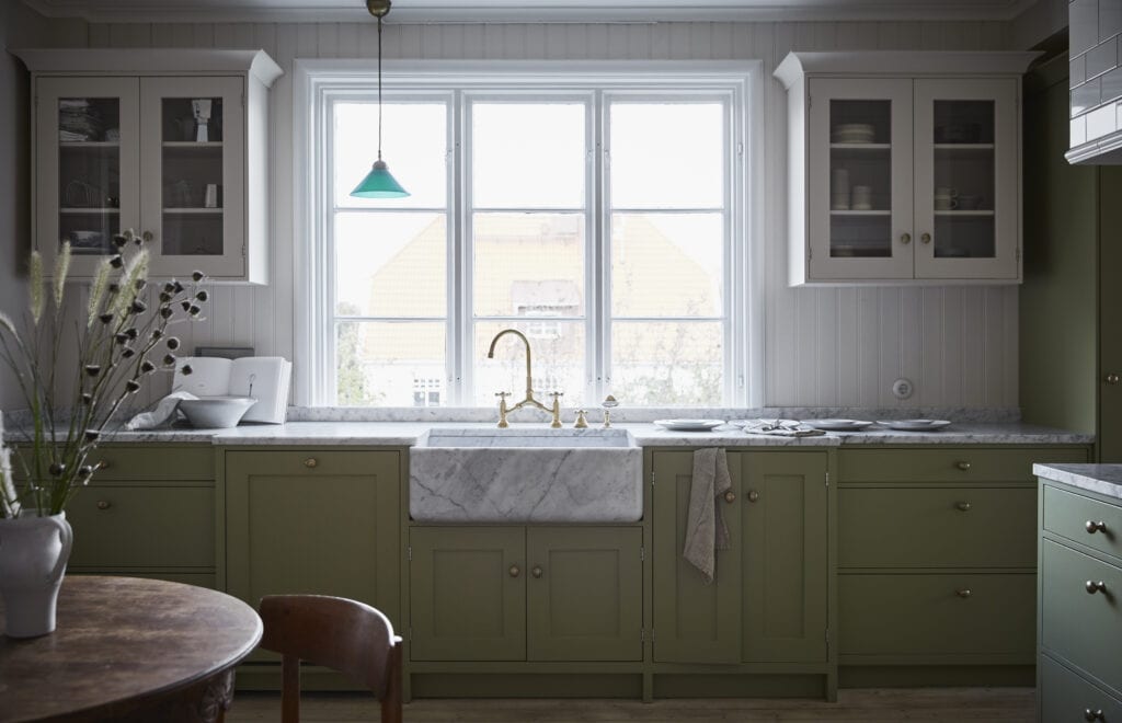 A classic green kitchen with a white marble sink 