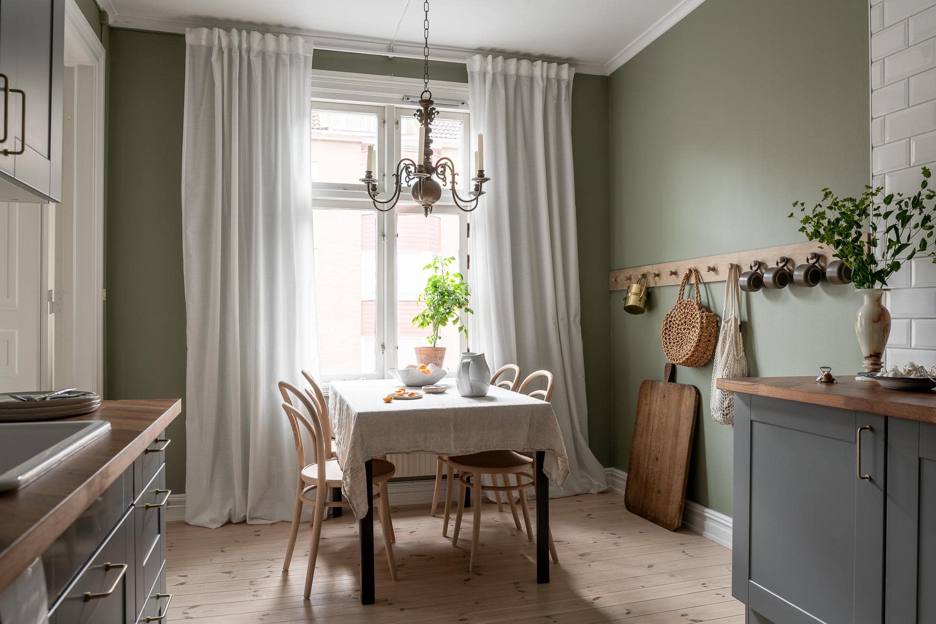 Grey kitchen cabinets against sage green walls in an attic apartment - COCO  LAPINE DESIGNCOCO LAPINE DESIGN