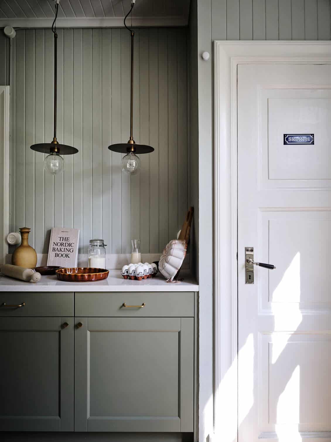 Sage green kitchen with shiplap walls in a Toronto home, Ontario