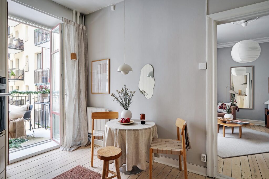 A kitchen dining area with grey walls, oak chairs