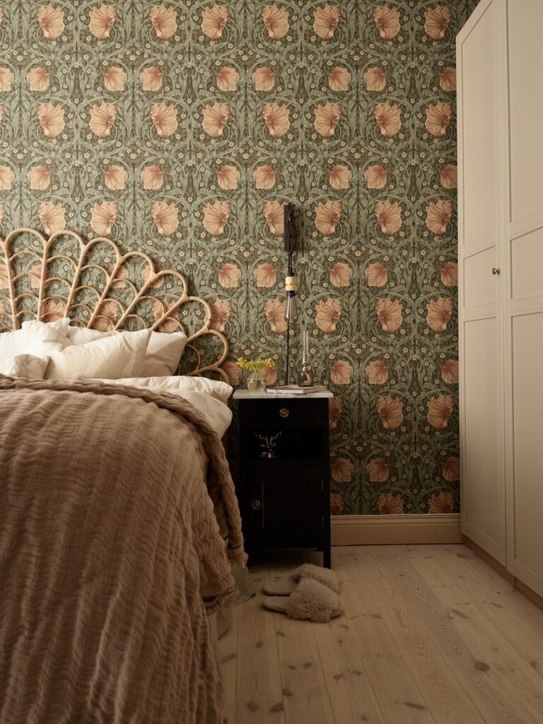 Bedroom wallpaper, Pimpernel design from Morris co in a romantic bedroom with a rattan headboard