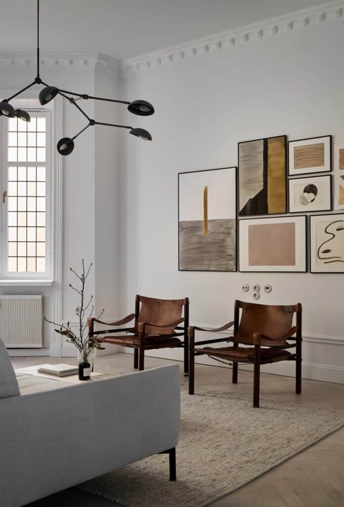 Vintage brown leather armchairs in combination with a gallery wall and a statement pendant light