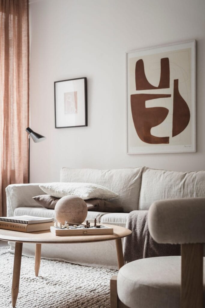 Earth tones in the art prints and accessories in a light palette living room