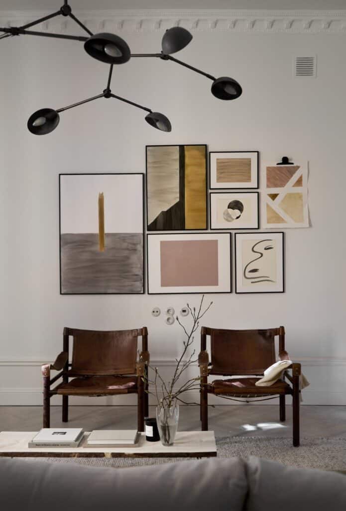 Vintage brown leather armchairs in combination with a gallery wall and a statement pendant light