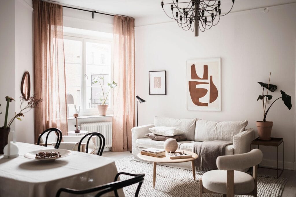 Earth tones in the art prints and accessories in a light palette living room