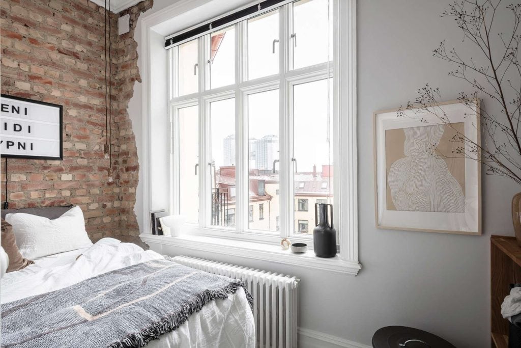 An elegant bedroom decor with an elegant separation between the brick and drywall portions