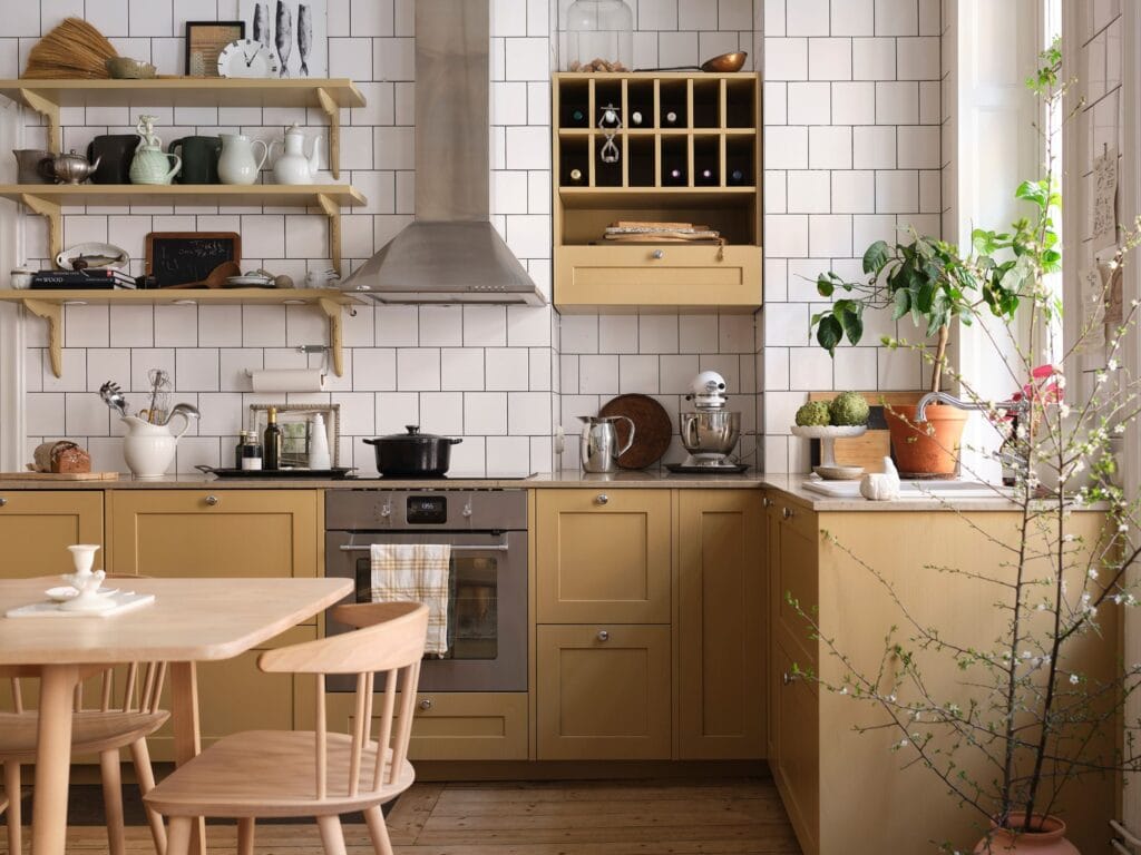 A yellow kitchen with white tiles and black grout