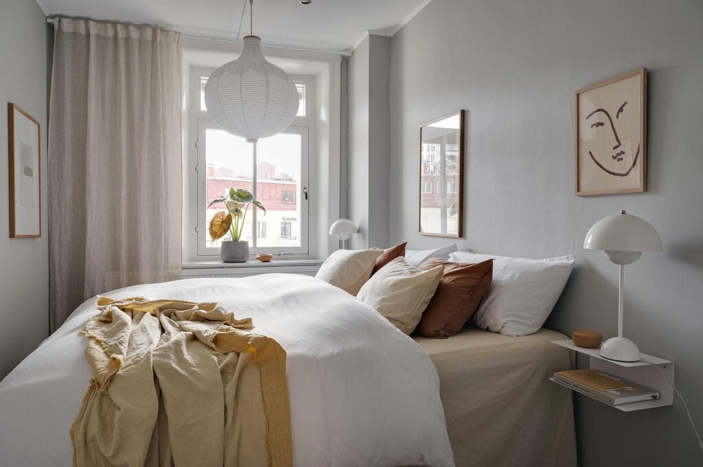 A small bedroom with light grey walls, bright color accents