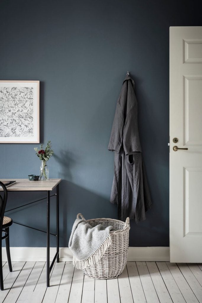 A bedroom with a deep blue wall color, home office spot