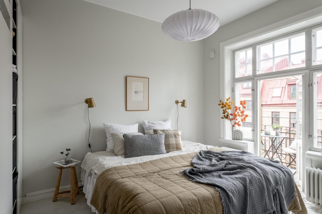 Light grey walls enhanced with natural tones in the bedding and throw pillows