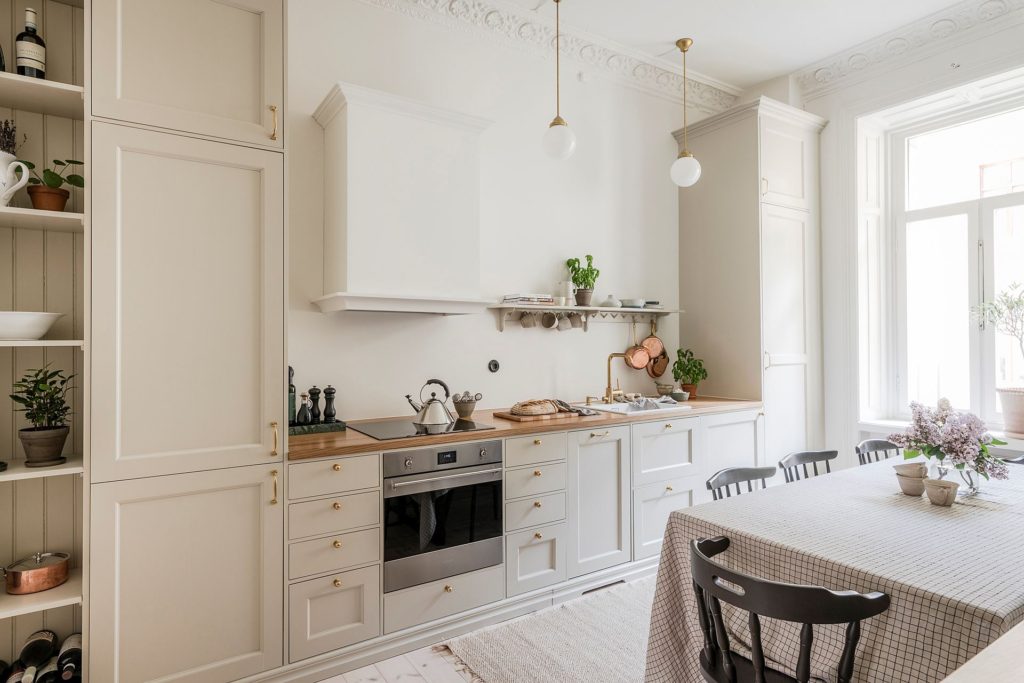 Antique white shaker cabinets and warm tones in a beautiful shaker kitchen