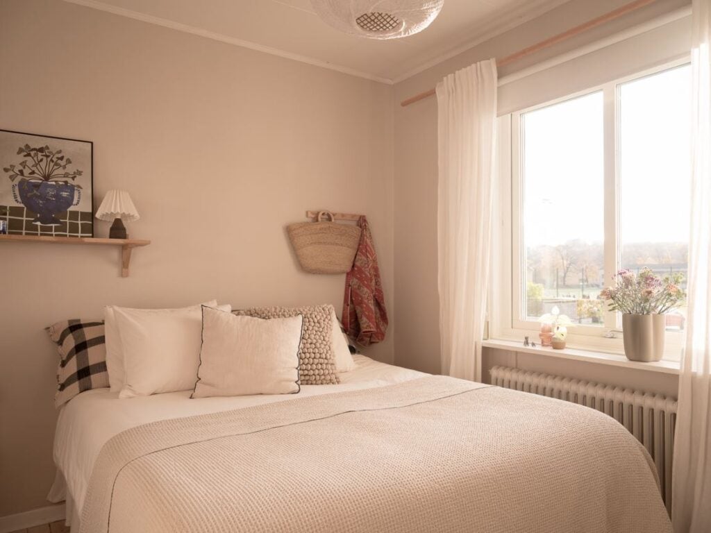 A bedroom with beige walls and a minimal decor