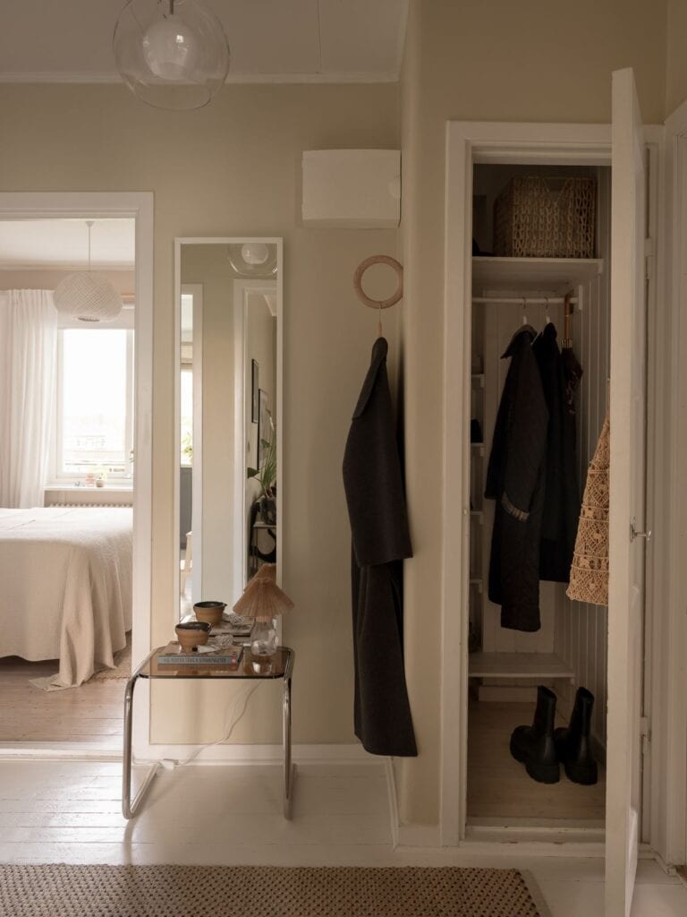  An entryway with beige walls with a green undertone and a walk-in closet
