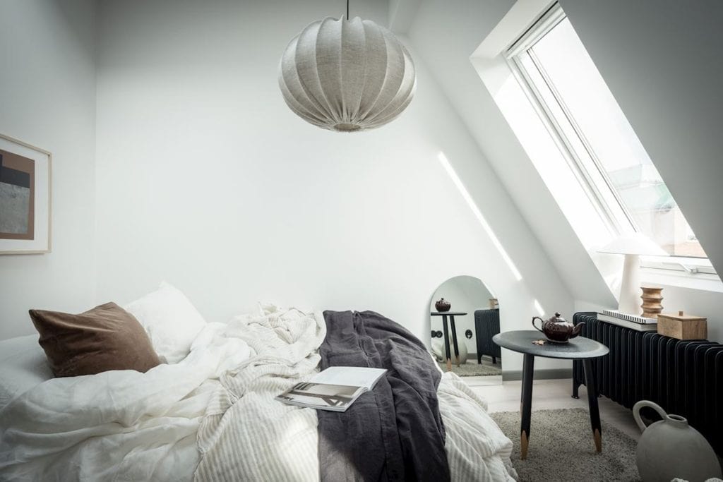 A black and white decor in an attic bedroom with a sky-light