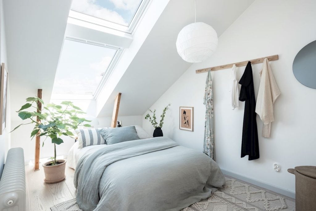 an attic bedroom with a double skylight ad a light blue color scheme