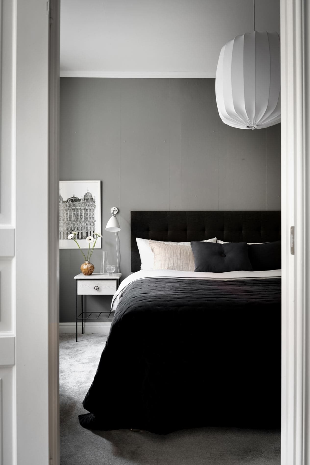 A grey bedroom paired up with a black headboard and comforter