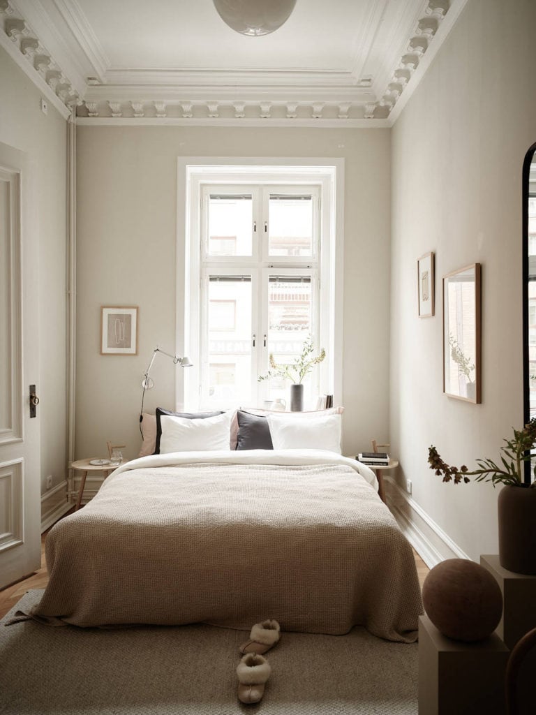 Light beige walls and impressive details on the crown molding in a historic bedroom 
