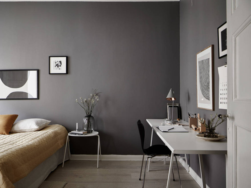 A dark grey bedroom enhanced with a yellow color palette in the textiles
