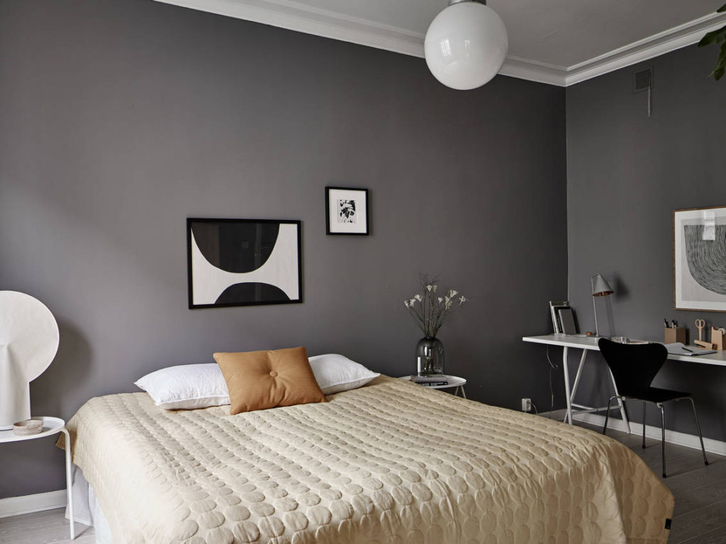 A dark grey bedroom enhanced with a yellow color palette in the textiles