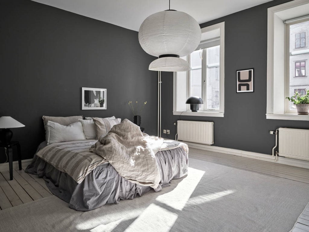 Charcoal grey bedroom walls contrast with white elements for a beautiful contrast