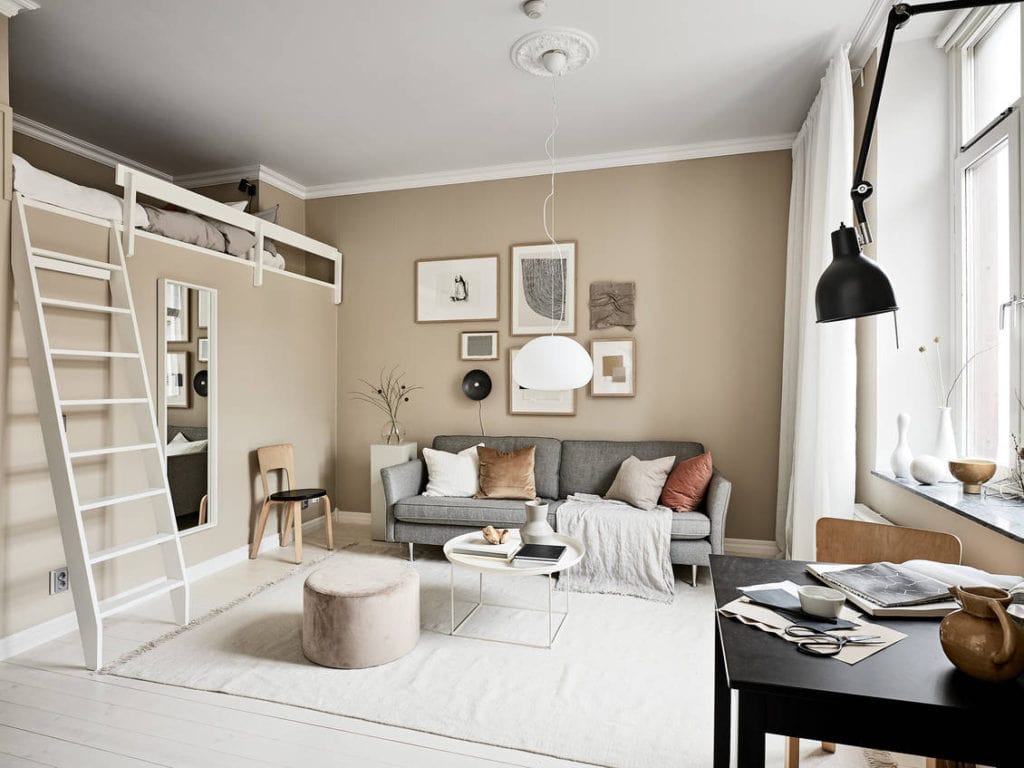 A loft bed in a beige studio apartment