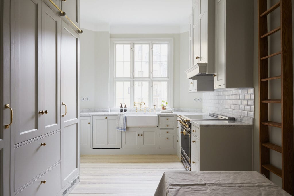 White shaker kitchen with brass hardware and a farmhouse sink